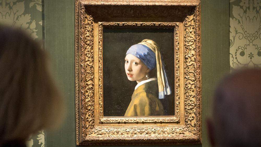 Ein Mann klebte seinen Kopf am Glas vor dem Gemälde Vermeers fest