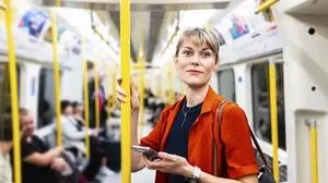 Woman with orange shirt standing in train model released, Symbolfoto, WPEF08904