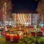 Rund um einen Brunnen beleuchtete Weihnachtshütten auf einem Adventmarkt, im Hintergrund ein Schloss | Das Spittaler Weihnachtsdorf eröffnet am 27. November