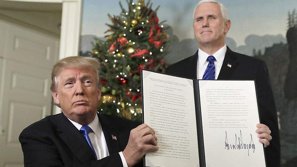 US-Präsident Donald Trump, im Hintergrund Vizepräsident Mice Pence. Trump hält die Deklaration in die Höhe, in der er erklärt, dass er Jerusalem als Hauptstadt Israels anerkennt 