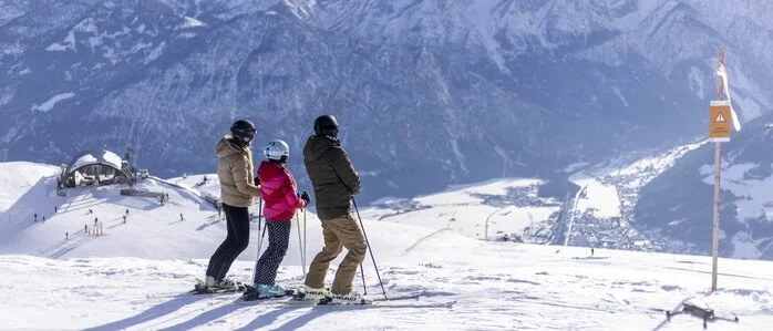 Eine Familie blickt vom Skigebiet Zettersfeld aus ins Tal