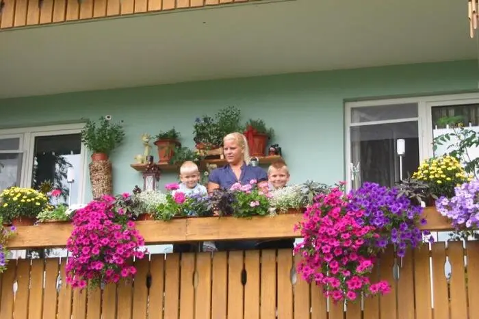 Pascal und Niklas Ebner helfen Mama Renate beim Gießen der Blumen.