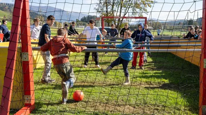 Personen kicken einen Fußball