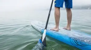 Man doing standup paddleboarding with oar on lake in foggy weather model released, Symbolfoto, PNEF03467