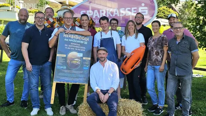 Ein Gruppenfoto mit verschiedenen Leuten vor einer sommerlichen Kulisse