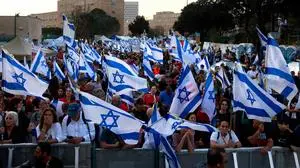 Israeli anti-government protesters wave flags at a four-day sit-in near the Parliament in Jerusalem on April 1, 2024, calling for the dissolution of the government and the return of Israelis held hostage in Gaza since the October 7 attacks by Palestinian Hamas militants. (Photo by Menahem Kahana / AFP)