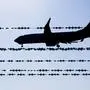 ABD0002_20250811 - LANGENHAGEN - DEUTSCHLAND: ++ ARCHIVBILD ++ ARCHIV - 17.02.2025, Niedersachsen, Langenhagen: Ein Flugzeug fliegt hinter Stacheldraht am Flughafen Hannover. (zu dpa: «Mehr als jeder zehnte Abgeschobene ist minderjährig») Foto: Julian Stratenschulte/dpa +++ dpa-Bildfunk +++. (ARCHIVBILD VOM 17.2.2025) - FOTO: APA/dpa/Julian Stratenschulte