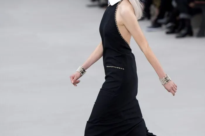Am Ende ehrte sie ihren Vorgänger, indem sie ein Model mit einem wadenlangen schwarzen Kleid und weißem hohen Kragen über den Laufsteg schickte.