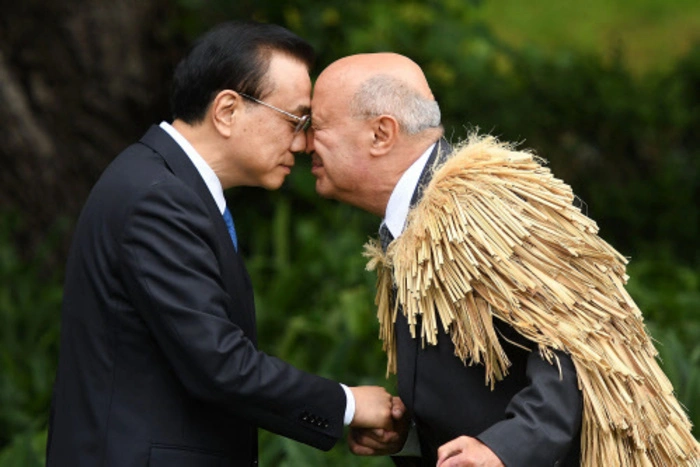 Chinas Premierminister wird in Neuseeland von einem Maori-Vertreter willkommen geheißen - Li Keqiang trägt die für ihn ungewöhnliche Begrüßung mit Fassung.