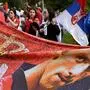 TOPSHOT - Members of the local Serbian community hold flags and banners outside a government detention centre where Serbia's tennis champion Novak Djokovic is staying in Melbourne on January 8, 2022, after he was dramatically refused entry to Australia over his Covid-19 vaccine status. (Photo by William WEST / AFP)