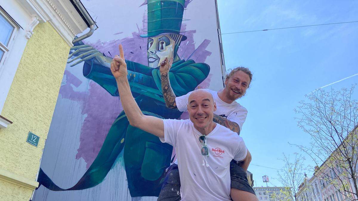 Tom Lohner und Stefan Ehrenreich (huckepack) vor dem Kunstwerk in der Wiener Straße