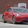 FILE - This Friday, July 19, 2019, file photo shows a Tesla vehicle charging at a Tesla Supercharger site in Charlotte, N.C. Tesla’s electric car sales accelerated again during the summer, but the company is still lagging behind the pace it needs to reach CEO Elon Musk’s goal for the entire year. (AP Photo/Chuck Burton, File)