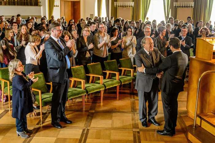 ... Die Subventionen wollen groß gefeiert werden, alle applaudieren, aber insgeheim hassen viele den eitlen Professor ...