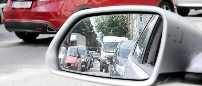 In einem Autoseitenspiegel sieht man die lange Autoschlange | Am Wochenende ist mit erhöhtem Verkehrsaufkommen zu rechnen