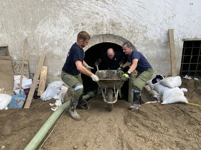 Gemeinsam gilt es, meterhohen Schlamm aus den Gebäuden zu beseitigen 