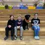 Die Schüler Tykhon, Nico und Anne-Marie freuen sich über den Unterricht mit Schulhund Angus (v.l.)