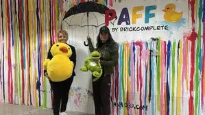 Damara Krienzer (Filialleitung bei Brickcomplete) und Künstlerin Diana Deu mit den Maskottchen, der Ente Paff und dem Drachen Filippo 