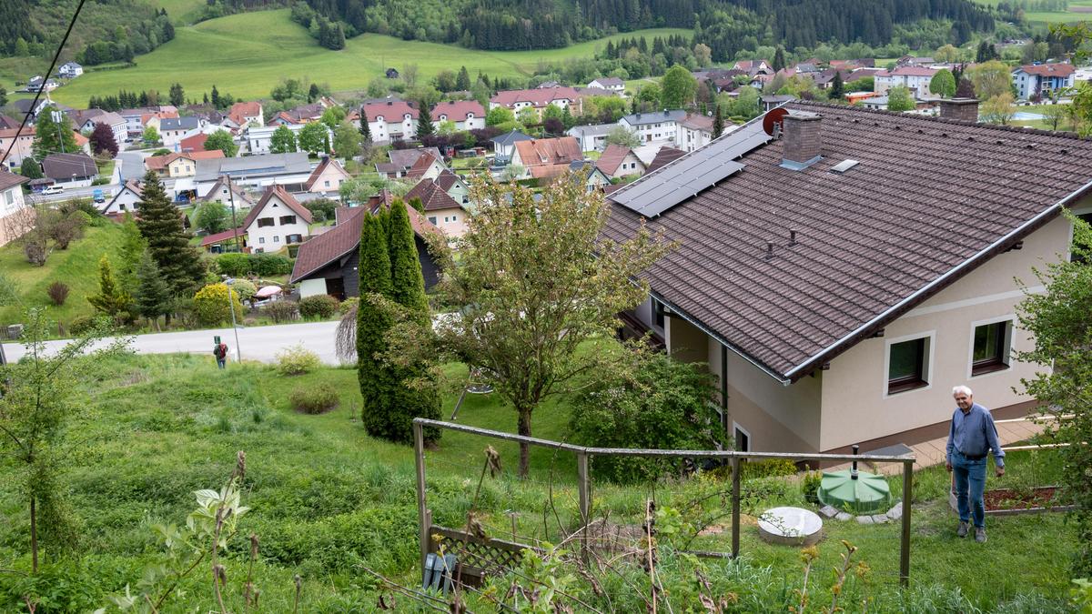 Werner Donis an der Stelle, an der er das Reh fand, dahinter sein Haus, im Hintergrund die Ortschaft Gurk