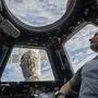 In this photo provided by NASA, U.S. astronaut and Expedition 66 Flight Engineer Mark Vande Hei peers at the Earth below from inside the seven-windowed cupola, the International Space Station's window to the world on Feb. 4, 2022. The Soyuz MS-19 crew ship is docked to the Rassvet module in the background. Vande Hei has made it through nearly a year in space, but in March 2022 faces what could be his trickiest assignment yet: riding a Russian capsule back to Earth in the midst of deepening tensions between the countries. (Kayla Barron/NASA via AP)