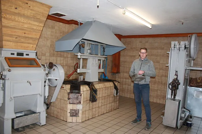 Robert Erschen junior erklärt die Bestandteile der Ölmühle mit Walzenstuhl, Röstpfannen und Stempelpresse.