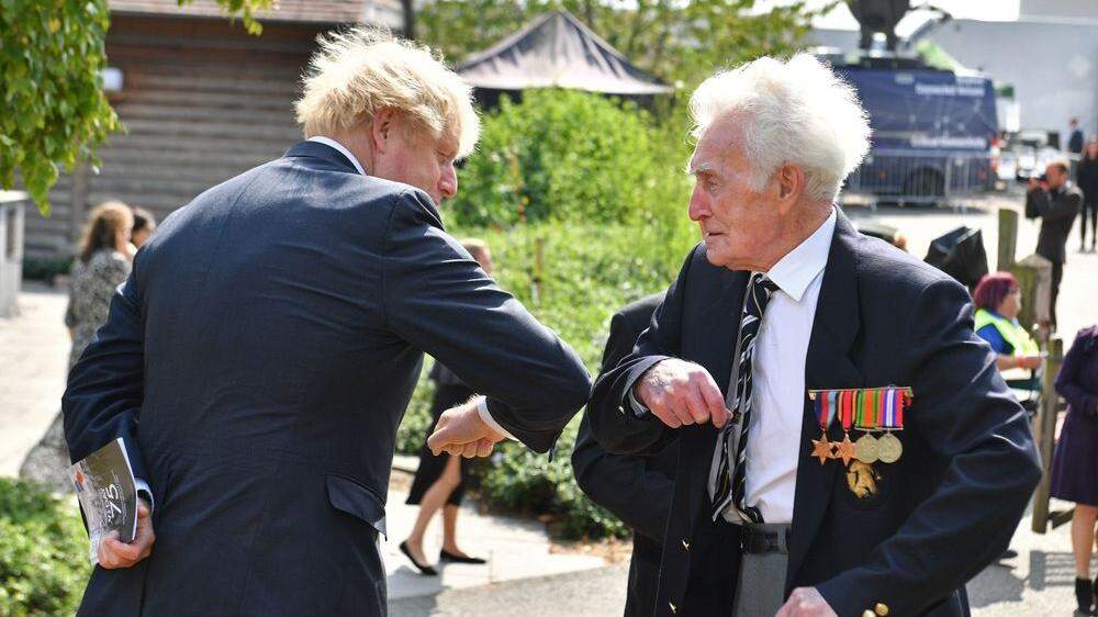 Johnson bei der Gedenkveranstaltung mit einem Veteranen aus dem Zweiten Weltkrieg
