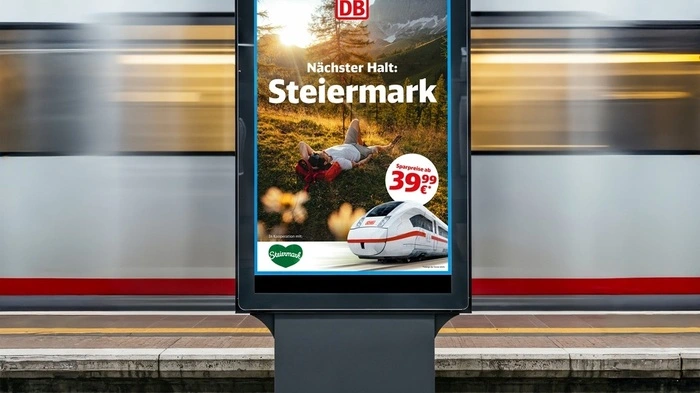 Das Bild zeigt die neue Werbekampagne auf einem Bildschirm an einem Bahnsteig