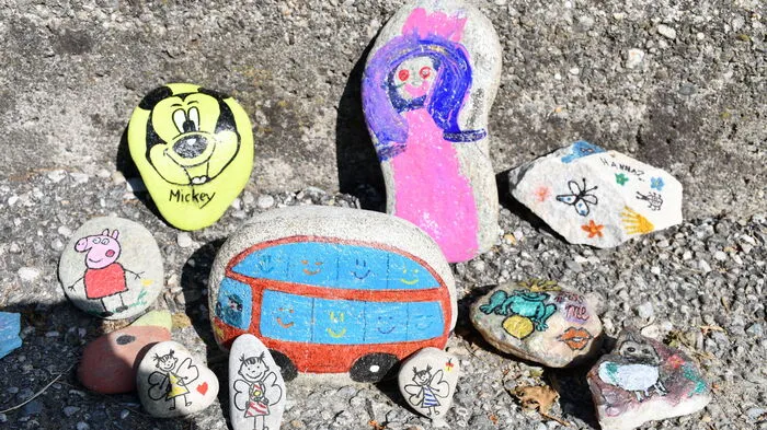 Entlang des Gartenzauns des Kindergartens in Baldramsdorf ist in der Corona-Zeit eine lange Schlange bunt bemalter Steine entstanden.