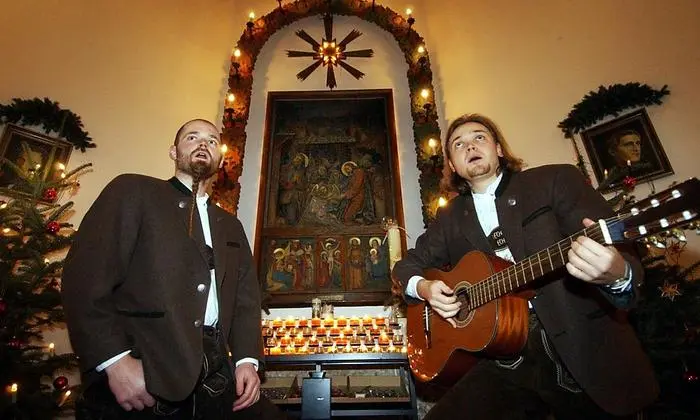 (FILES) In this file photo taken on December 10, 2003 Markus Giglmayer (L) sings a Silent night carol with his brother Christian to visitors at The Silent-Night-Memorial-Chapel, in the Austrian village of Oberndorf. - The Silent-Night-Chapel stands on the original site of St. Nikolaus Church where Christmas carol 