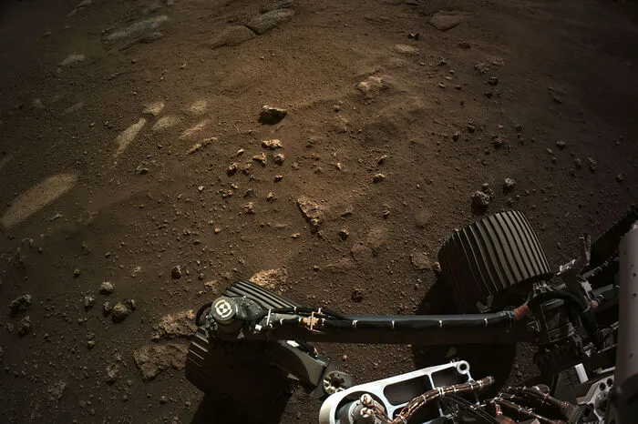 Das Bild zeigt unter anderem Geröll, Hügel und den Horizont rund um den "Jezero Crater", einen ausgetrockneten See mit einem Durchmesser von etwa 45 Kilometern, den "Perseverance" in den kommenden zwei Jahren untersuchen soll.