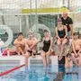 Trainer Gernot Poduschka mit seiner jungen Schwimm-Gruppe und Sarah-Maria Baumegger zu seiner Rechten