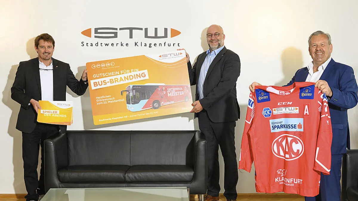KAC-Geschäftsführer Oliver Pilloni freut sich über den Gutschein für ein Busbranding, der ihm von Erwin Smole und Andreas Waldher überreicht wurde.