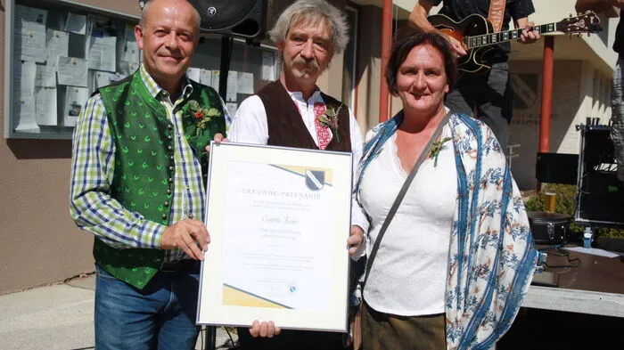 Für 25 Jahre Coppla Kaša-Fest erhielt Vereinsobmann Robert Kauer (Mitte) von Bürgermeisterin Lisa Lobnik eine Ehrenurkunde überreicht. Am Bild mit dem Vorstandsmitglied der Vellachtaler Bergbauern Gabriel Hribar (links).