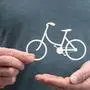 Man holding a paper bicycle; Symbol of bicycle insurance
