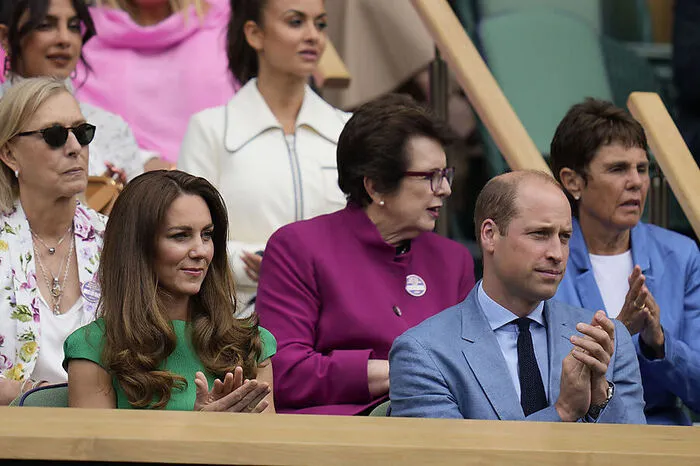 ...Prinz William und seine Frau Herzogin Kate, die auch Schirmherrin des Ausrichters All England Lawn Tennis Club ist, blicken.
