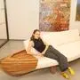 Eine junge Frau sitzt auf einem Sofa, das aus einem Holzboot gebaut wurde