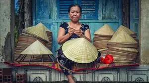 Vietnamese Old woman craftsman making the traditional vietnam hat in the old traditional house in Ap Thoi Phuoc village, Hochiminh city, Vietnam, traditional artist concept