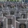 Ukrainian servicemen walk among graves at the Field of Mars cemetery in Lviv on August 24, 2024 to commemorate the fallen soldiers on the occasion of the Independence Day Of Ukraine, amid the Russian invasion of Ukraine. (Photo by Ivan STANISLAVSKY / AFP)