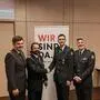 Vier Männer in Uniform lachen in die Kamera