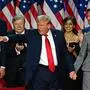 TOPSHOT - Former US President and Republican presidential candidate Donald Trump gestures at supporters after speaking as he holds hands with former US First Lady Melania Trump during an election night event at the West Palm Beach Convention Center in West Palm Beach, Florida, early on November 6, 2024. Republican former president Donald Trump closed in on a new term in the White House early November 6, 2024, just needing a handful of electoral votes to defeat Democratic Vice President Kamala Harris. (Photo by Jim WATSON / AFP)