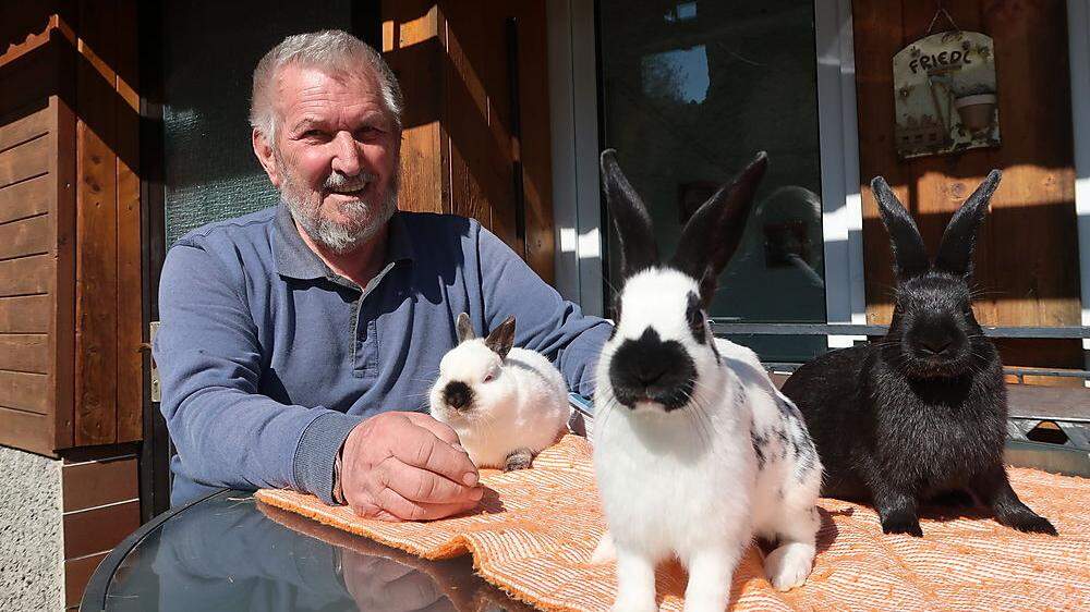 August Friedl mit drei seiner Kaninchen