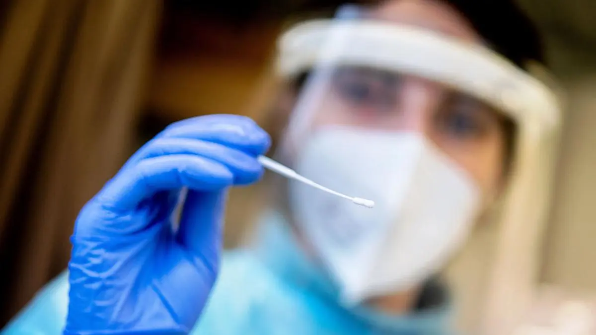 ABD0015_20211205 - OLDENBURG - DEUTSCHLAND: 05.12.2021, Niedersachsen, Oldenburg: Eine Mitarbeiterin einer Teststation in der Innenstadt hält ein Stäbchen für einen tiefen Rachenabstrich in der Hand. In Niedersachsen gelten in vielen Bereichen verschärfte Corona-Regeln. Foto: Hauke-Christian Dittrich/dpa +++ dpa-Bildfunk +++. - FOTO: APA/dpa/Hauke-Christian Dittrich