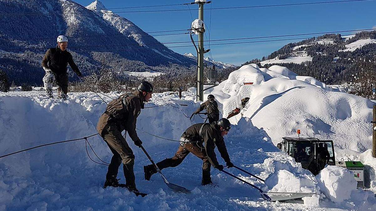 Die Soldaten tragen den Schnee händisch von den Dächern ab, um die Einsturzgefahr der Gebäude zu verhindern