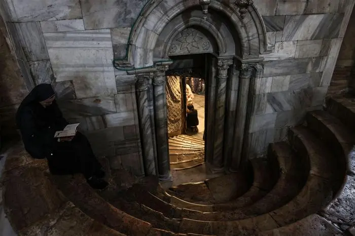A Christian nun sits on the steps of the Grotto, located under the Basilica, the alleged spot where Jesus Christ was born, in the Church of the Nativity, in the West Bank town of Bethlehem on December 21, 2025. Christmas cheer returned to the traditional birthplace of Jesus Christ in early December 2025, as Bethlehem lit up a tree for the first time since the war in Gaza began over two years ago. (Photo by HAZEM BADER / AFP)