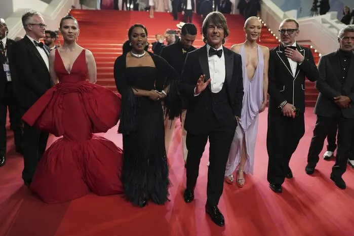 Cruise zeigte sich bestens gelaunt, gekleidet in einem klassischen Anzug und Piloten-Sonnenbrille sowie langen Haaren grinste er neben seinen Kollegen.
