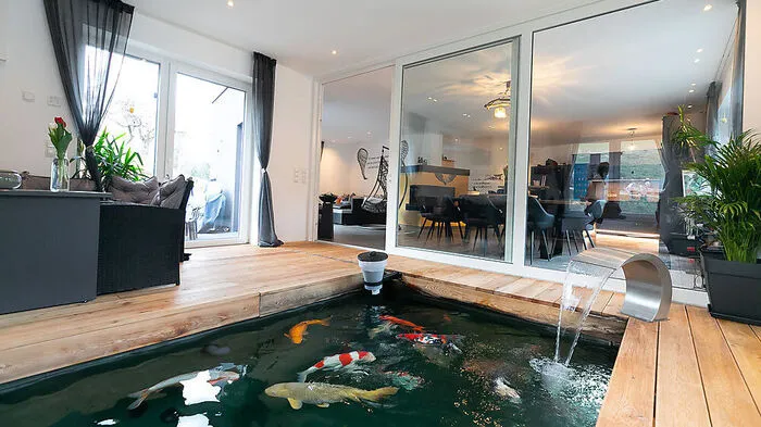 Eine Glasfront sorgt für offene Atmosphäre zwischen Koi-Zimmer und den Wohnräumen.
