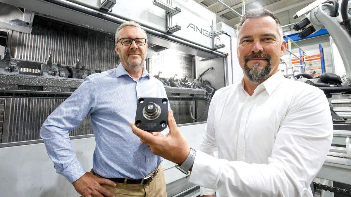 Patrick Plamenig, Geschäftsführer von Kosmek Europe (rechts) und Dietmar Bahn (Anger Machining) mit  einem Nullpunkt-Spannsystem von Kosmek