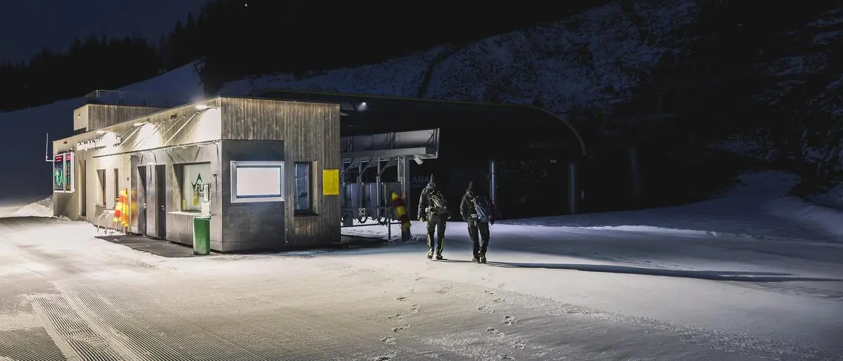 17.12.2025, Schladming, Steiermark, Österreich (Austria): Unterwegs auf der Planai bei der Lärchkogelbahn, einer 8er-Sesselbahn, mit dem langjährigen Seilbahnbediensteten Günter Schmid und Betriebsleiter Silvester Grogl sowie Lehrling Lilli Heyder, um einen Blick hinter die Kulissen des Seilbahnbetriebs zu werfen. Bild zeigt Silvester Grogl und Günter Schmid beim morgendlichen Weg zur Arbeit in der Nähe der Talstation der Lärchkogelbahn. 
Fotocredit: Martin Huber