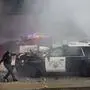 A California Highway Patrol officer pulls an electric scooter off a vehicle on a highway as protesters throw objects at the police vehicles near the Metropolitan Detention Center in downtown Los Angeles, Sunday, June 8, 2025. (AP Photo/Ethan Swope)