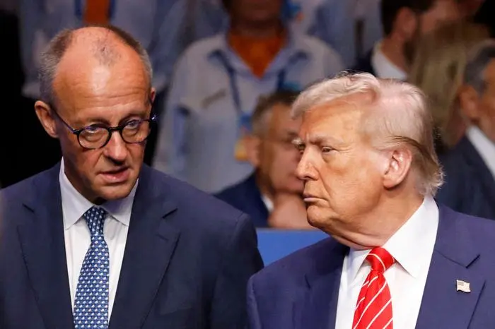 Germany’s Chancellor Friedrich Merz (L) speaks with US President Donald Trump before the start of the North Atlantic Council plenary meeting at the North Atlantic Treaty Organisation (NATO) summit in The Hague on June 25, 2025.  (Photo by Ludovic MARIN / POOL / AFP)