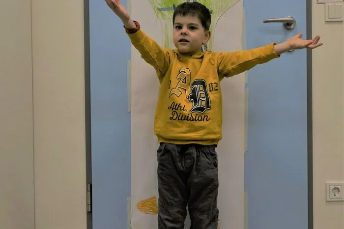 Auch künstlerisch kann Tim sich austoben - das Bild an der Wand hinter ihm hat er gemeinsam mit seiner Therapeutin gestaltet.